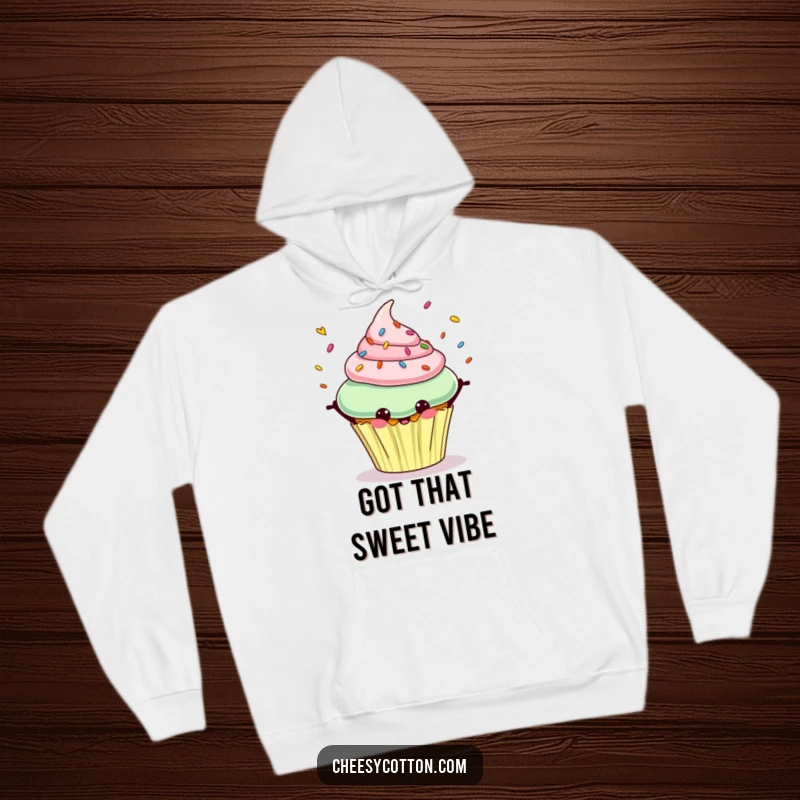 Funny hoodie featuring a cheerful cupcake character happily juggling colorful sprinkles with a beaming smile.