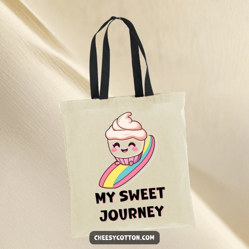 Funny tote bag with a smiling cupcake character with mischievous eyes, sliding down a rainbow, perfect for carrying treats.
