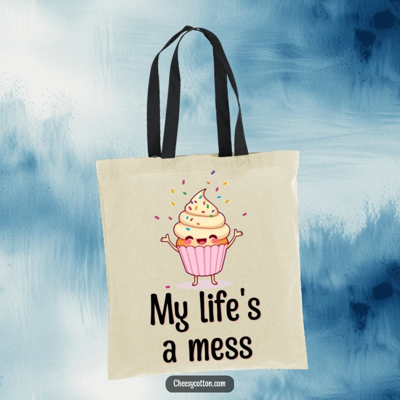 Funny cupcake character happily juggling sprinkles on a durable tote bag, a practical and humorous accessory.
